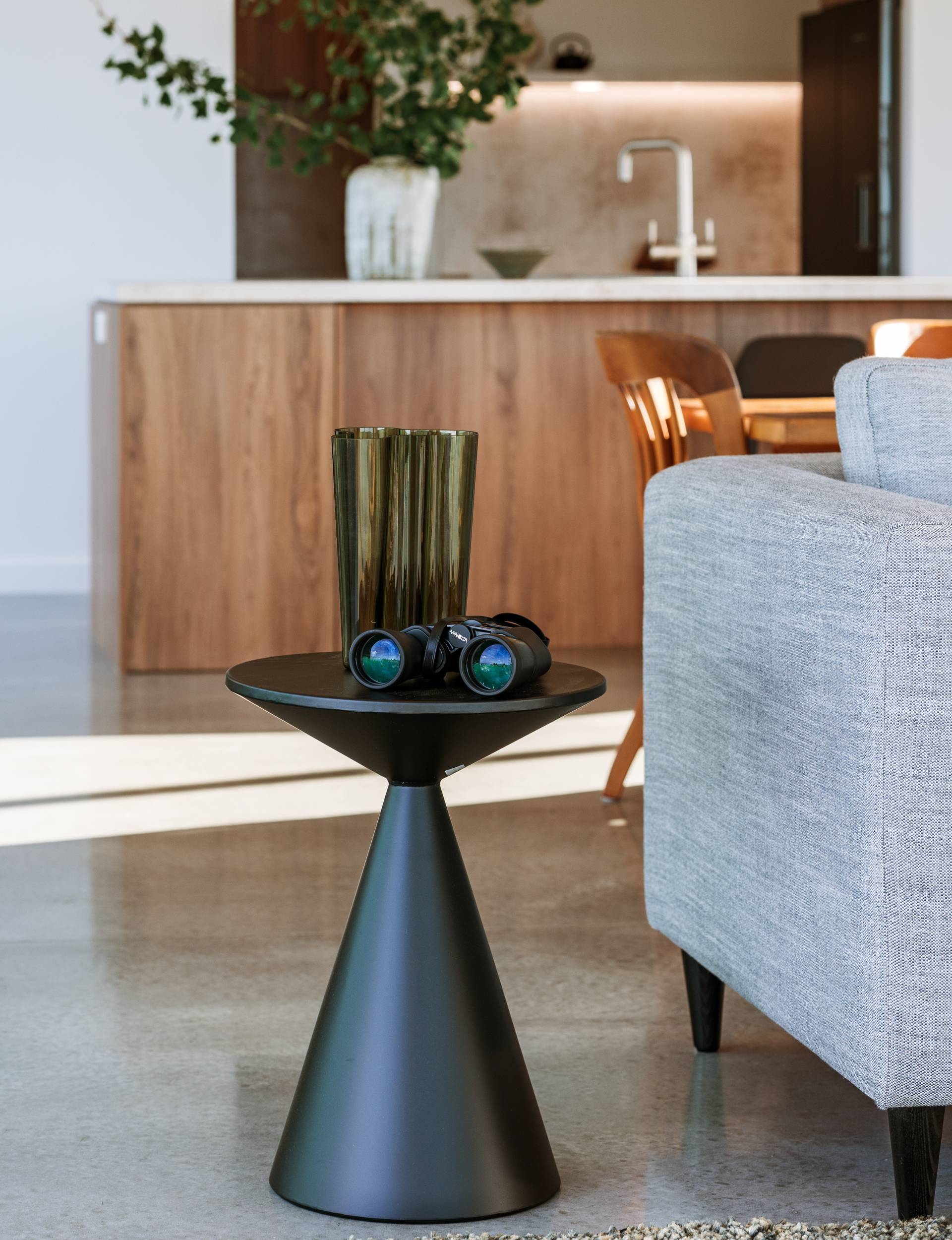 A black coffee table beside a grey couch